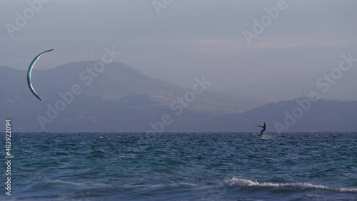 Kiteboarding. Kite surfer rides the waves, Tarifa Spain. Sports activity. Kitesurfing action. Slow motion.