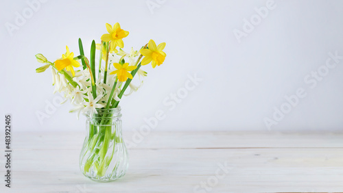 Wallpaper Mural Yellow daffodils and white hyacinth flowers in crystal vase on wooden tabletop. Image with copy space Torontodigital.ca