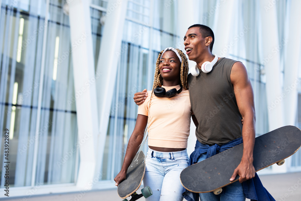 Obraz premium Beautiful urban couple having fun outdoors. Portrait of an excited young couple with skateboard.