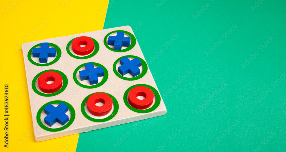 tic-tac-toe board game concept on yellow and green background with copy space - obrazy, fototapety, plakaty 