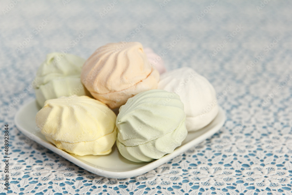 Delicious fresh multicolored marshmallow lies on a serviced table in saucer Delicious fresh multicolored marshmallow lies on a serviced table in saucer