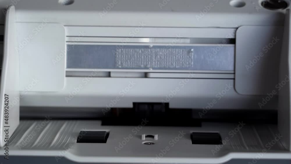 Hand puts money in a currency counting machine counting dollar bills. Money counting equipment for paper money calculation. Mechanism for bank financial operations. Currency exchange Hand puts money in a currency counting machine counting dollar bills. Money counting equipment for paper money calculation. Mechanism for bank financial operations. Currency exchange
