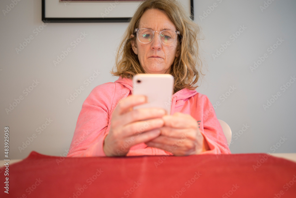 Stockholm, Sweden A middle-aged woman at a table with a mobile phone. Stockholm, Sweden A middle-aged woman at a table with a mobile phone.
