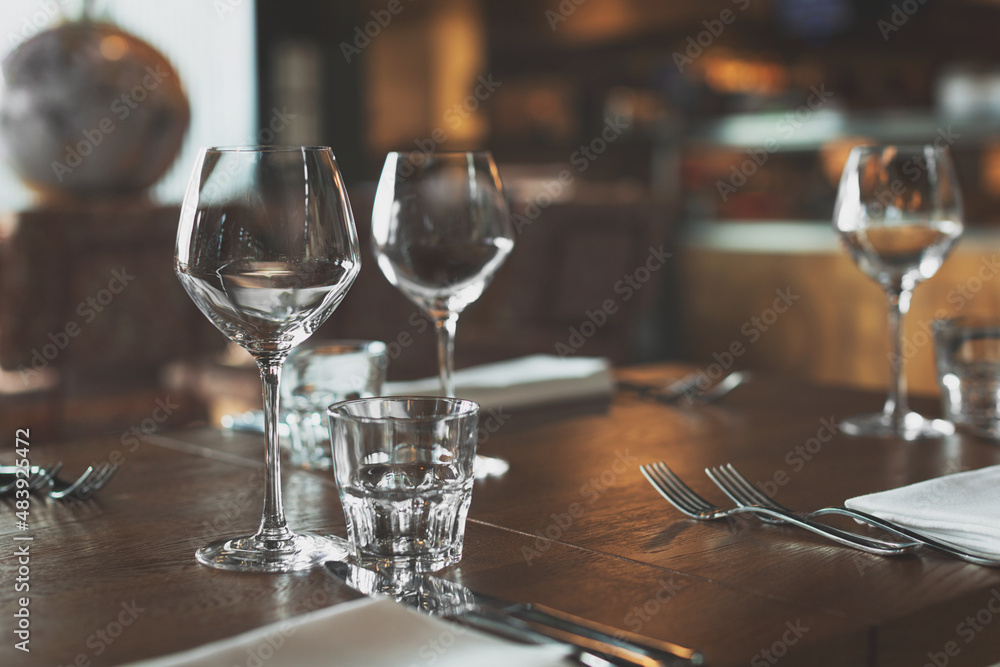 Empty glasses and cutlery on the table. Breakfast, dinner or lunch preparation in the restaurant or hotel.