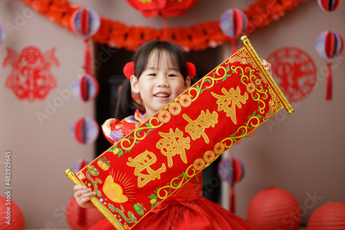 Εκτύπωση καμβά young Chinese girl with traditional dressing up holding kung hei fat choy gree
