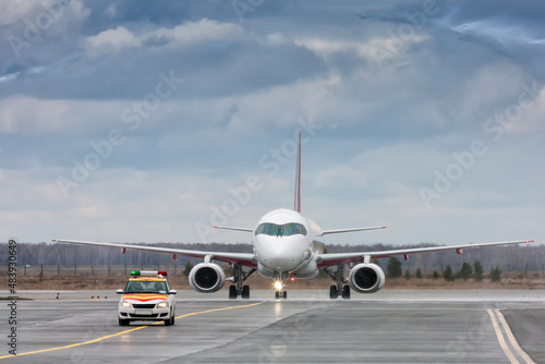 A passenger airplane taxiing run the follow-me-car through a water salute in honor of the first visit © Dushlik