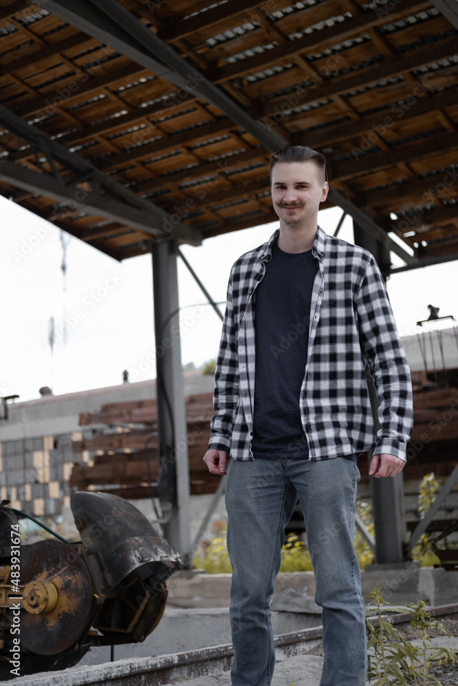 Portrait of man with mustache in checkered black and white shirt outside. Portrait of man with mustache in checkered black and white shirt outside.