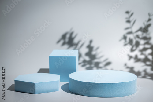 Abstract minimalistic scene with geometric forms. podium on blue background with shadows. product presentation, mock up, show cosmetic product display, Podium, stage pedestal or platform.