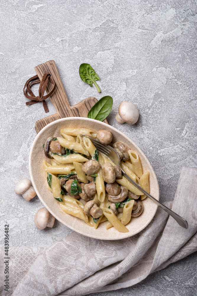 Bowl of pasta and mushrooms in cream sauce with spinach Bowl of pasta and mushrooms in cream sauce with spinach