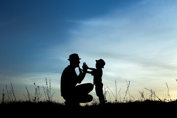 silhouette of father and son play on sunset