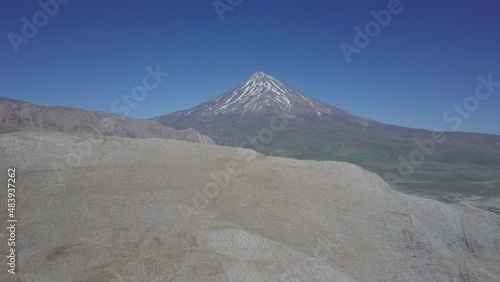 A beautiful Drone flight moving up showing Damavand mountain in Iran and a blue sky