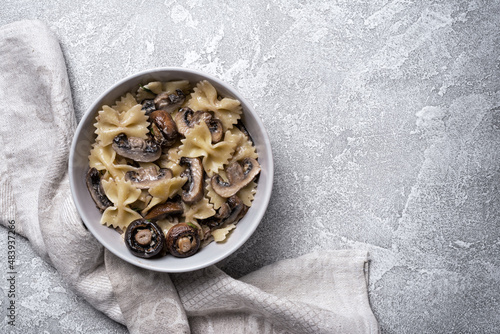 Bowl of italian farfalle pasta and mushrooms with cream sauce