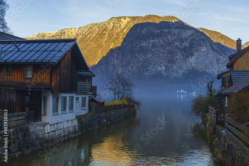 Old traditional Austrian houses on a mountain lake shore on winter sunset