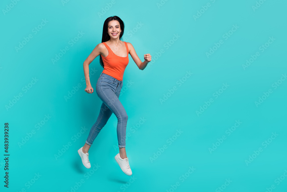 Photo of shiny cute woman wear red singlet jumping high running empty space isolated teal color background