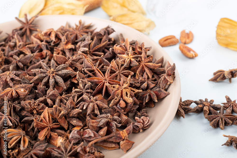 Star anise seasoning in a plate on a light tablecloth Star anise seasoning in a plate on a light tablecloth