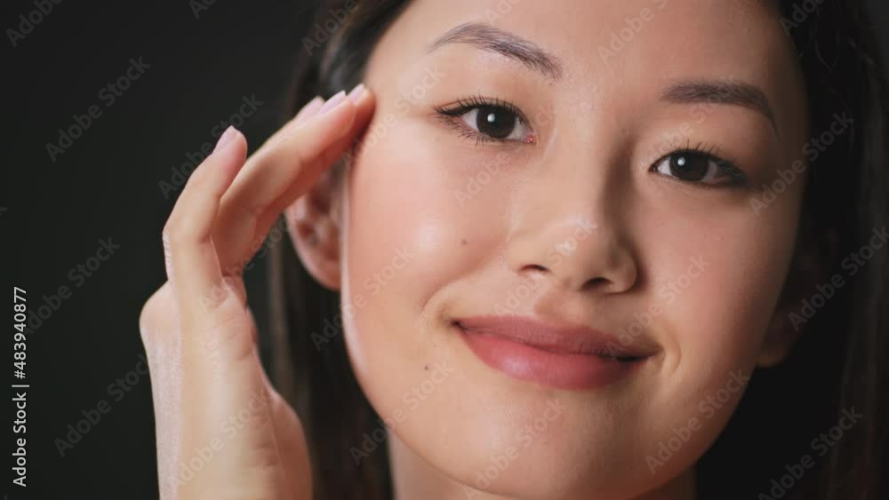 Youth and beauty concept. Close up portrait of young asian lady touching her smooth perfect skin, looking at camera Youth and beauty concept. Close up portrait of young asian lady touching her smooth perfect skin, looking at camera