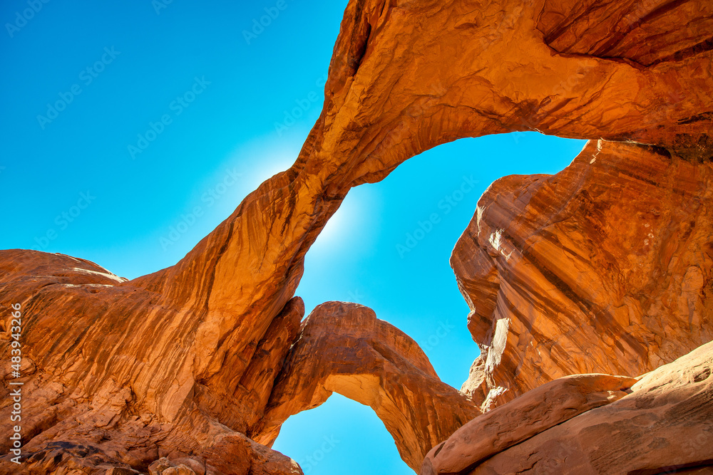 Double Arch ia a natural rock formation inside Arches National Park, Utah. Landscape under a blue sky