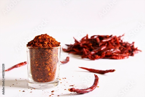 red hot chili pepper in a glass blurred dried chili peppers beside photo isolate on white front view copy space 