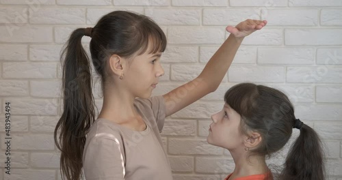 Measuring height in childhood. A playful children measure her height in the room. photo