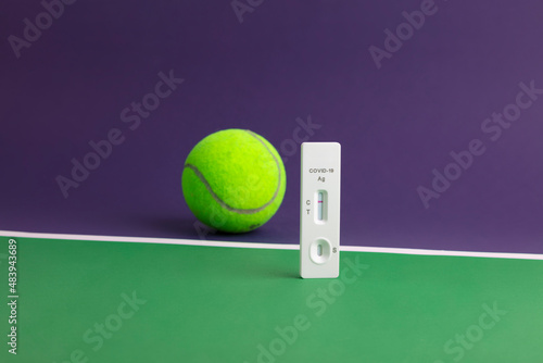 Pelota de tenis sobre pista de tenis y test negativo de Covid-19 en campeonato mundial de Wimbledon photo