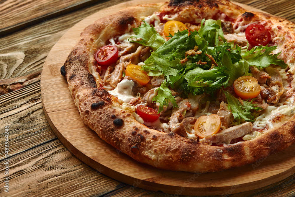 Pizza Caesar. Pizza with chicken, tomato, cheese and lettuce on wooden board. Top view. Free space for your text. Delivery food Pizza Caesar. Pizza with chicken, tomato, cheese and lettuce on wooden board. Top view. Free space for your text. Delivery food