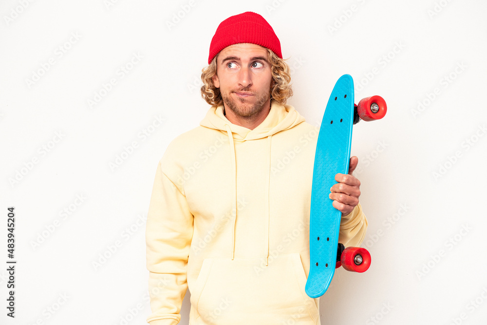 Young skater caucasian man isolated on white background confused, feels doubtful and unsure. Young skater caucasian man isolated on white background confused, feels doubtful and unsure.