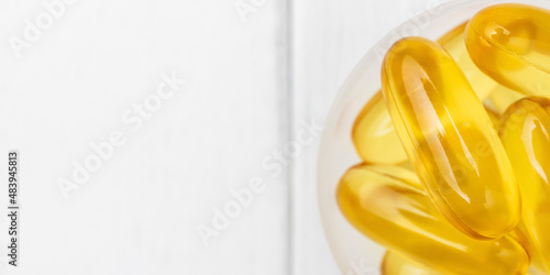 Omega-3 yellow capsules in a plastic scoop, nutritional supplements, close-up, top view