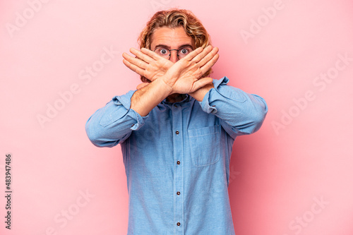 Φωτογραφία Young caucasian man isolated on pink background doing a denial gesture