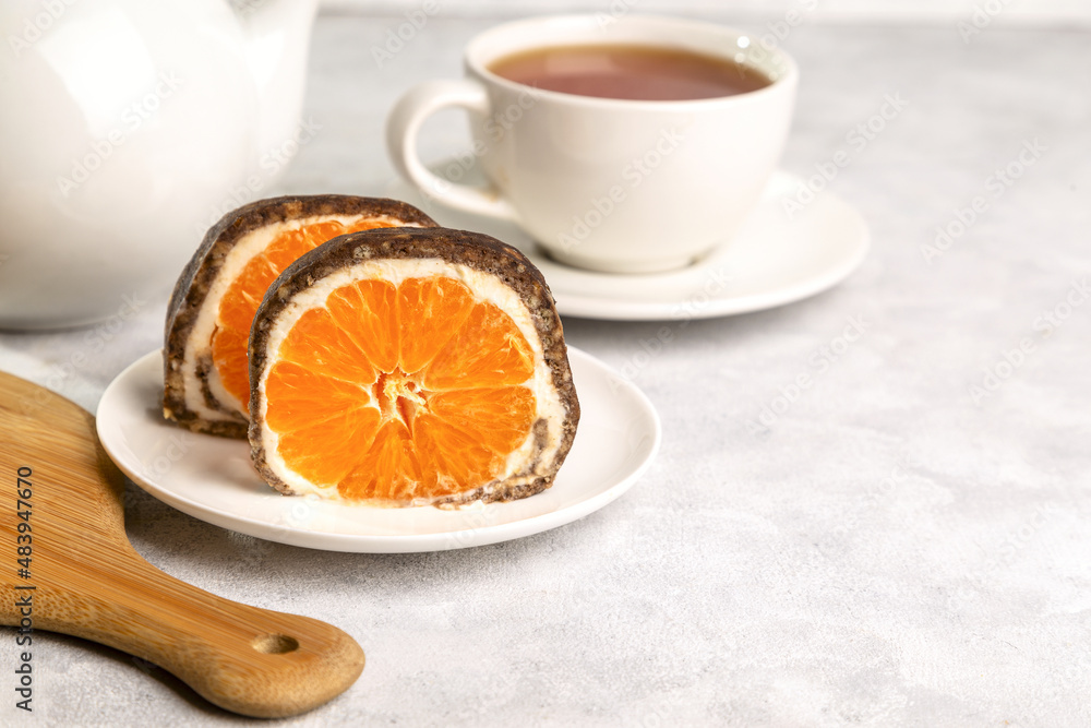 Sweet chocolate roll with tangerine filling and a cup of hot tea. Sweet chocolate roll with tangerine filling and a cup of hot tea.