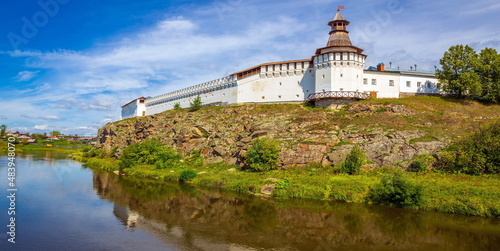 Russia, Verkhoturye, July 2021: Tura river and Verkhoturye Kremlin with Trinity Cathedral on a summer sunny day. photo