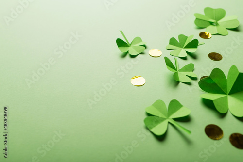 St. patrick's day. green background with clover leaves: shamrock and four-leafed, coin or confetti. copy space. Paper craft