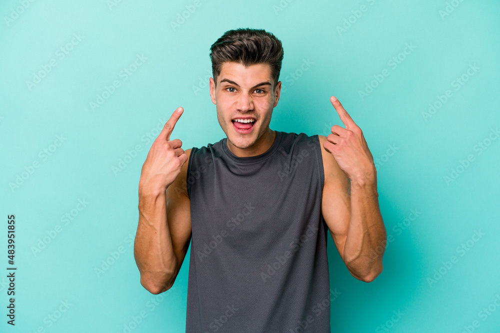 Young caucasian man isolated on blue background showing a disappointment gesture with forefinger. Young caucasian man isolated on blue background showing a disappointment gesture with forefinger.