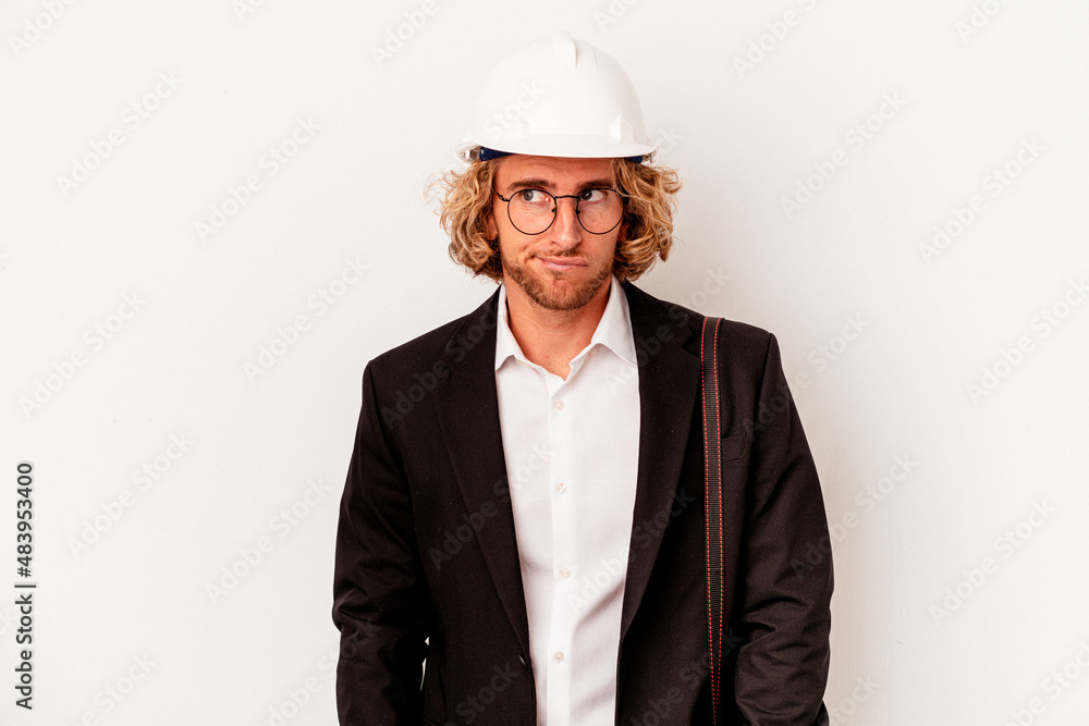 Young architect caucasian man with helmet isolated on white background confused, feels doubtful and unsure. Young architect caucasian man with helmet isolated on white background confused, feels doubtful and unsure.