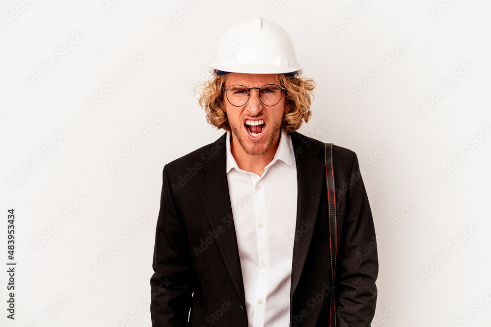 Young architect caucasian man with helmet isolated on white background screaming very angry and aggressive. Young architect caucasian man with helmet isolated on white background screaming very angry and aggressive.