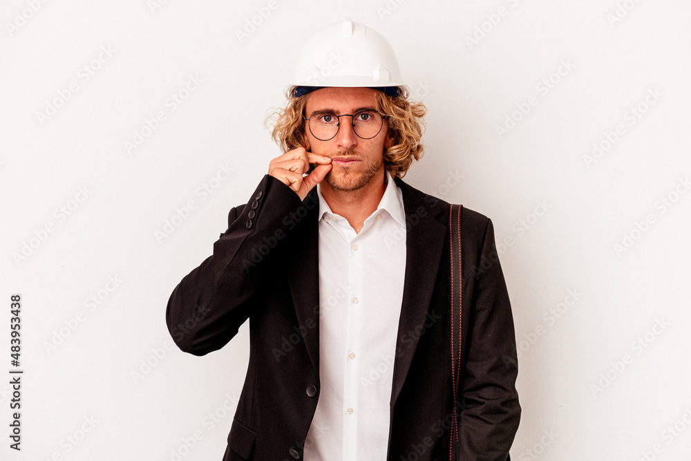 Young architect caucasian man with helmet isolated on white background with fingers on lips keeping a secret. Young architect caucasian man with helmet isolated on white background with fingers on lips keeping a secret.