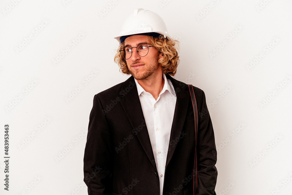 Young architect caucasian man with helmet isolated on white background looks aside smiling, cheerful and pleasant. Young architect caucasian man with helmet isolated on white background looks aside smiling, cheerful and pleasant.