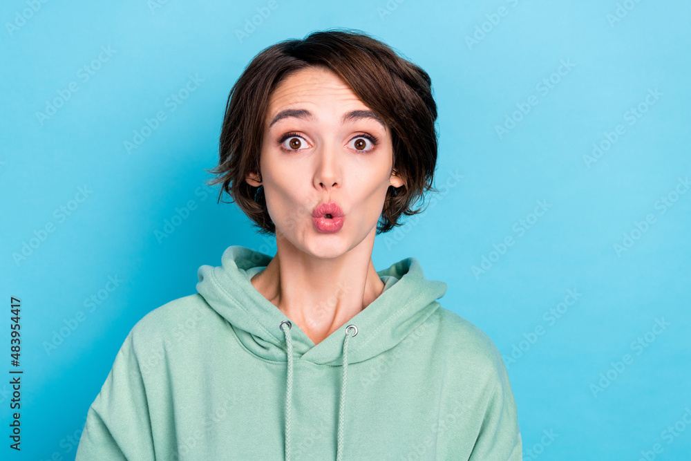Photo of cute young bob hairdo lady look camera wear green pullover isolated on blue color background Photo of cute young bob hairdo lady look camera wear green pullover isolated on blue color background