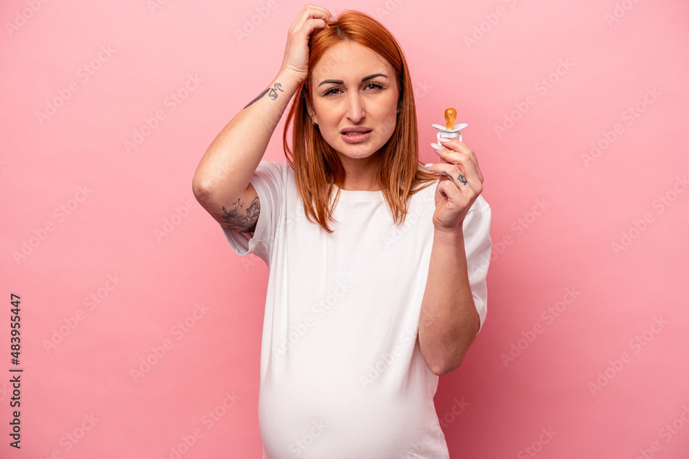 Young caucasian pregnant woman holding pacifier isolated on pink background being shocked, she has remembered important meeting. Young caucasian pregnant woman holding pacifier isolated on pink background being shocked, she has remembered important meeting.