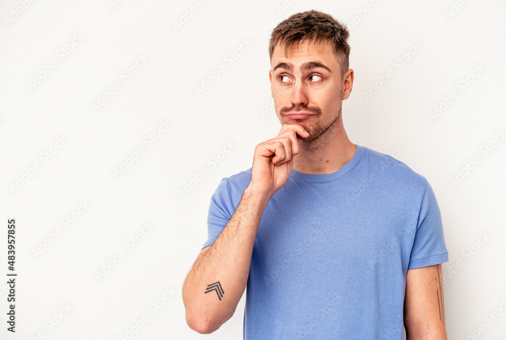 Young caucasian man isolated on pink background looking sideways with doubtful and skeptical expression. Young caucasian man isolated on pink background looking sideways with doubtful and skeptical expression.