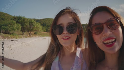 Two Asian young women having fun and enjoy vlogging from on the beach. Summer vacation at sea for a happy female...Young adult woman who is carefree and freedom. Lifestyle, blogger travel photo