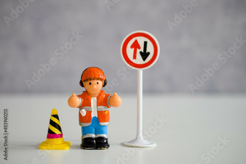 миниатюрная кукла - мужчина или женщина рядом с дорожным знаком 