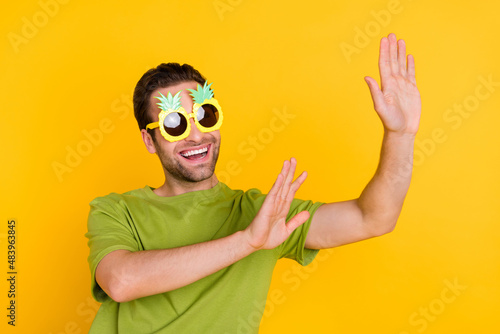 Photo of young cheerful man have fun clubber dance chill wear eyeglasses isolated over yellow color background