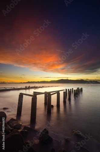 Abandoned pillars in a beautiful scenery of the sunset at the beach