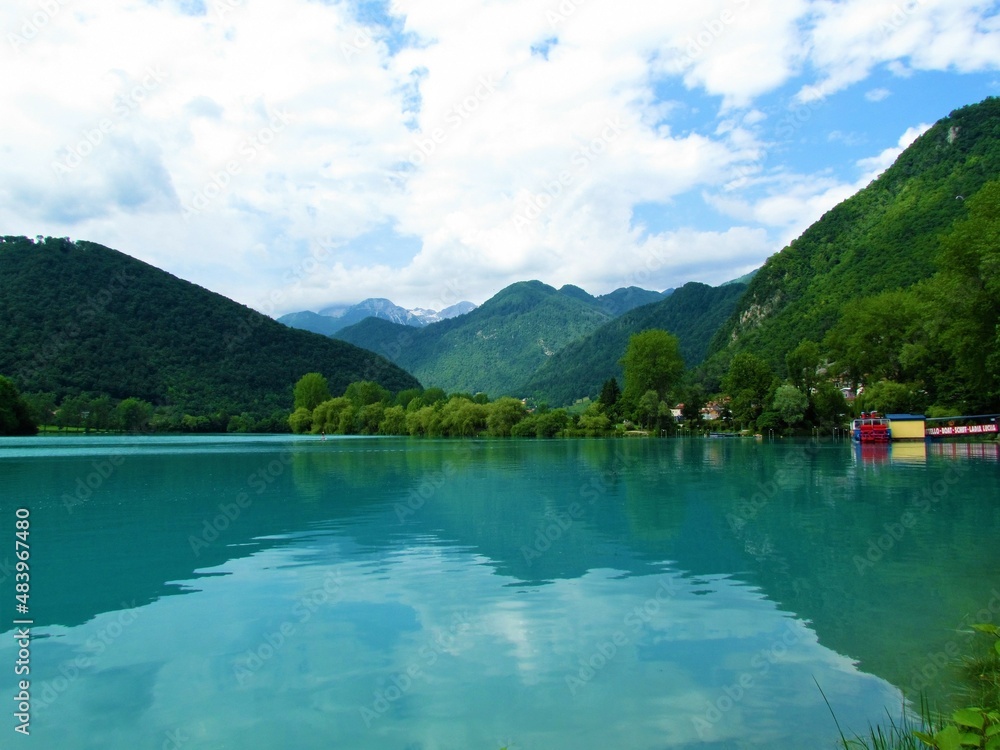 Turquoise colored lake at Most na Soci in Littoral region of Slovenia and mountains in Julian alps behind in the summer