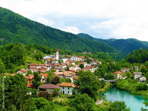 Scenic village Most na Soci in littoral region of Slovenia surrounded by forest coverd hills and Soča riber in front in summer