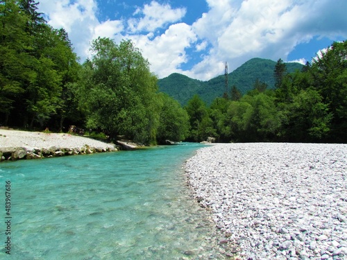 Tolminka river in Littoral region of Slovenia with rock alluvium andforest covered hills behind photo