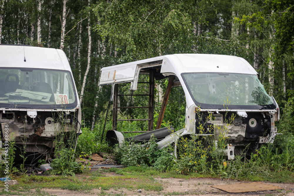 Disassembled abandoned cars in the forest in summer. Outdoors