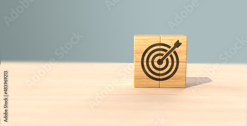 Business goal and success concept. Focus on a goal and achieve successful business. Initiation for planning to reach target. Darts target aim icon on wooden cubes with grey background. Copy space.
