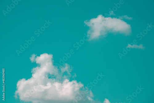 Photography Photo of aqua blue sky with a group of white clouds in hard light contrast background
