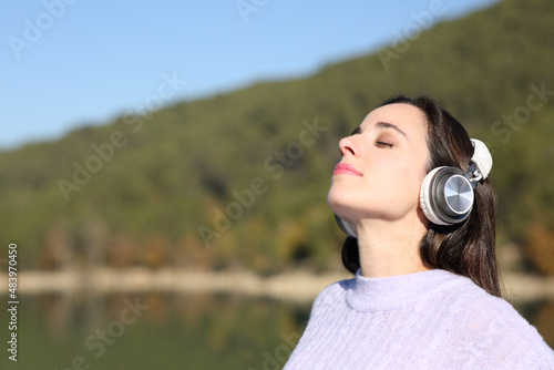 Woman meditating with headphones in a lake